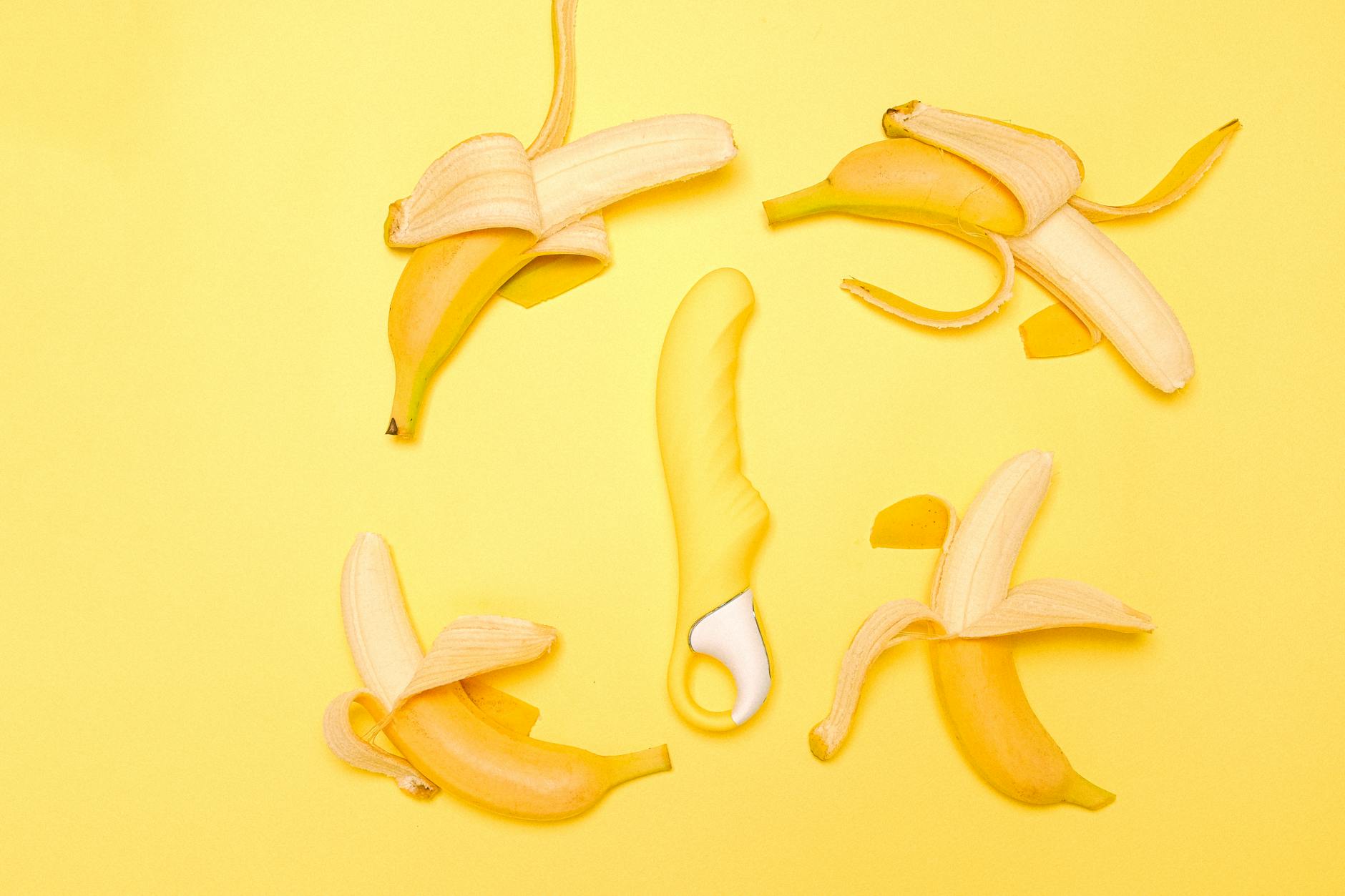 Yellow silicone vibrator on a soft yellow background