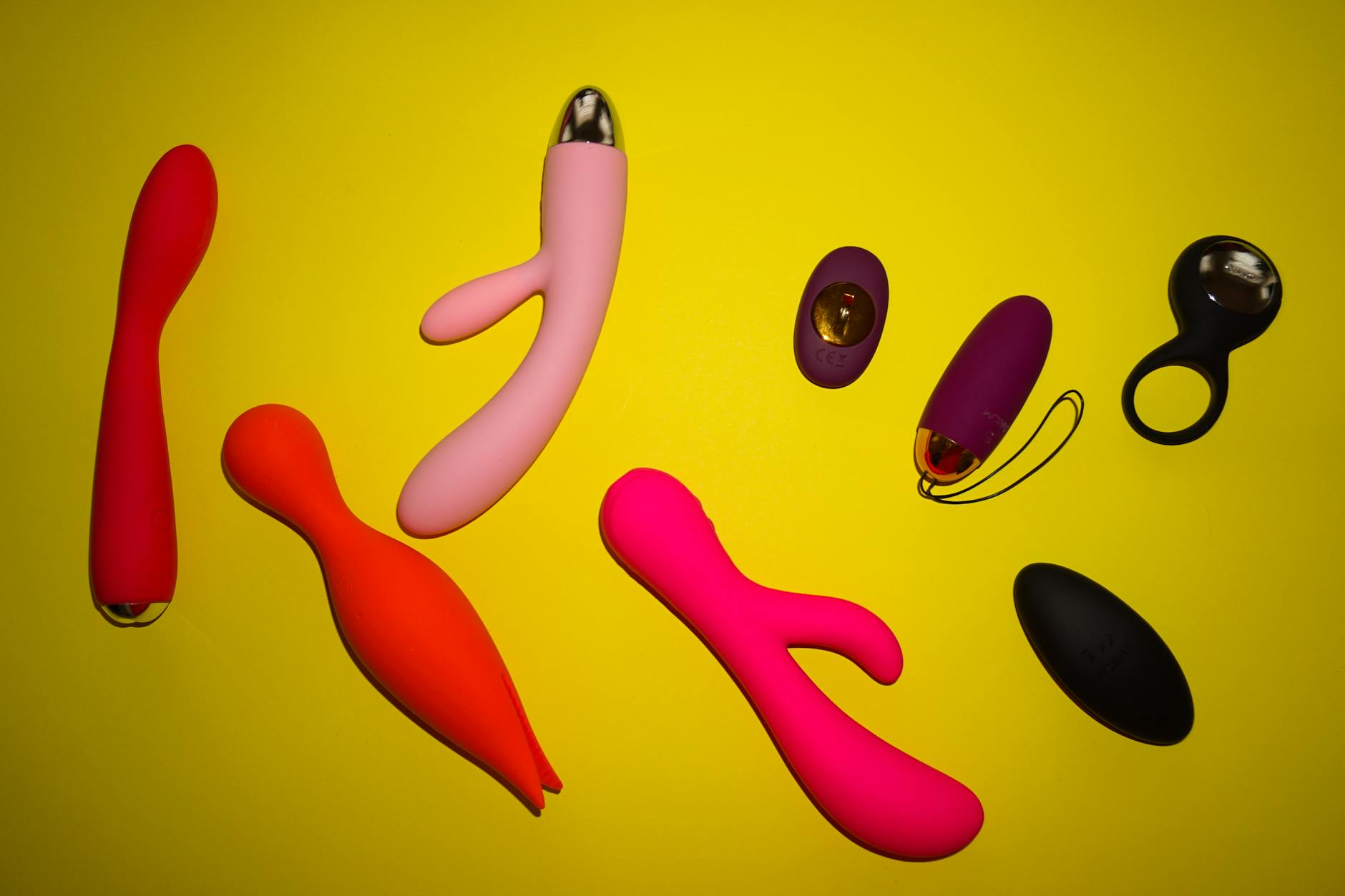 Two hands holding pink and blue silicone vibrators against a pastel background, symbolizing shared exploration and renewed connection