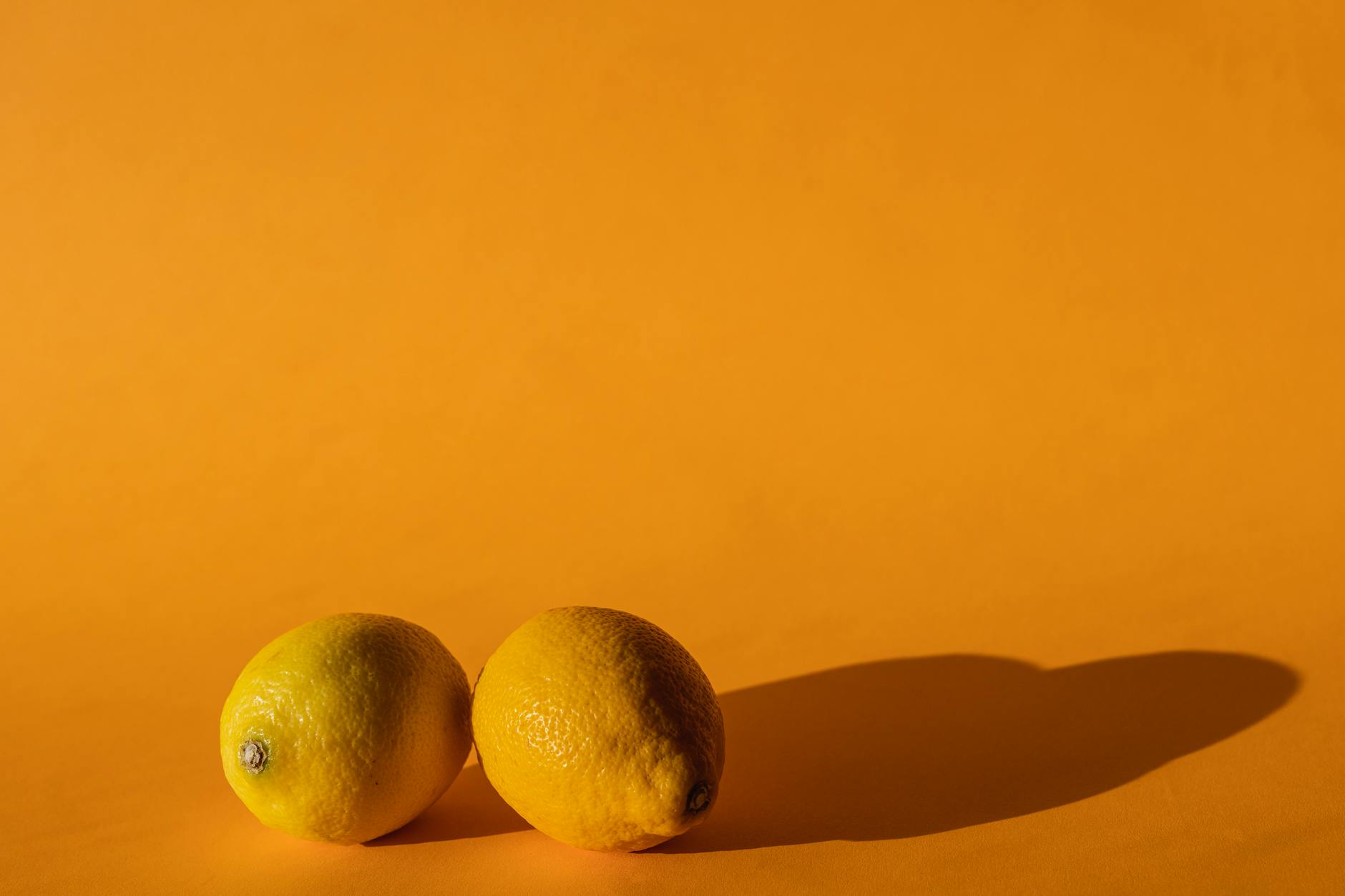 Fresh ripe lemons on a bright yellow background in studio lighting